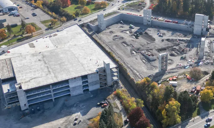Vue aérienne, à l’automne, du stationnement à étages partiellement construit sur le nouveau campus de L’Hôpital d’Ottawa. La moitié de la structure est achevée; elle comporte plusieurs niveaux et est recouverte par un toit. 