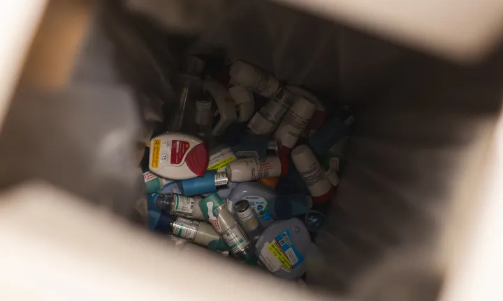 Vue à l’intérieur d’un contenant de déchets médicaux montrant une grande quantité d’aérosols-doseurs jetés.