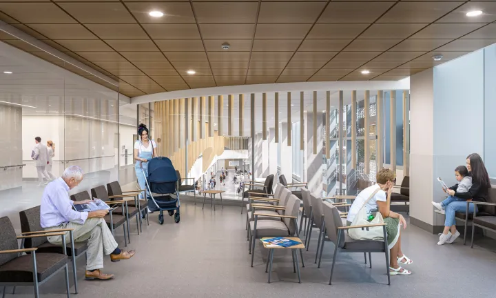 An artist rendering of the interior of a waiting room at The Ottawa Hospital’s new campus.  A few people are seated at various locations, and a woman is entering the room pushing a baby stroller. Two of the walls of the room are glass; the one on the left shows the hallway outside the room while the background wall shows the main floor concourse of the hospital below.