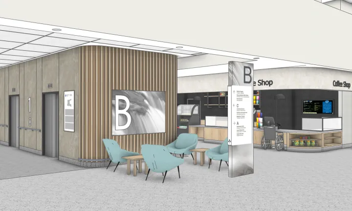 An artist rendering of a close-up perspective of a bank of elevators and a coffee shop inside the main entrance of a new hospital. On the left are two elevator doors with the number 1 on the wall between them. A large letter B is on a sign on the wall around the corner from the elevator doors, with 4 green chairs in front of it.