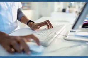 A doctor working at a computer terminal