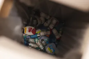 A view into a medical waste container showing a large collection of discarded inhalers.