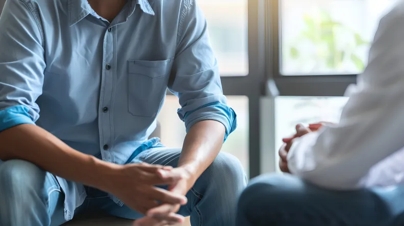 Un professionnel de santé et un patient assis pour une consultation en santé mentale.