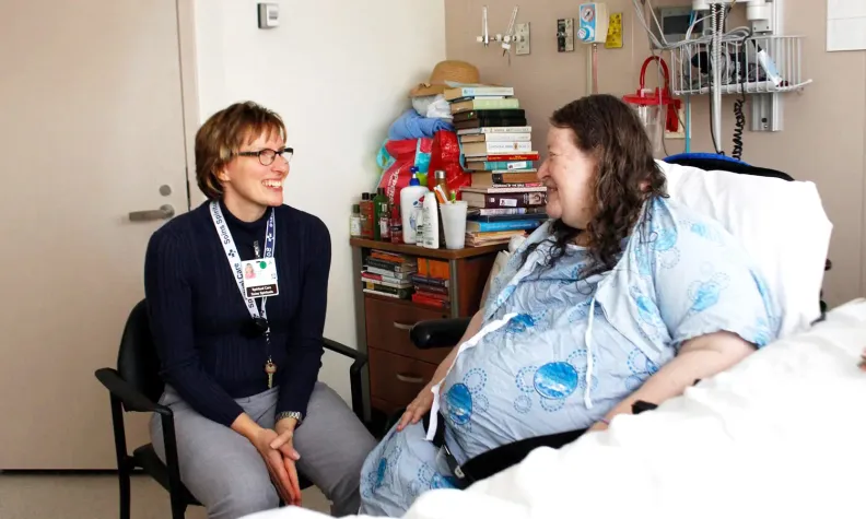 Intervenante en soins spirituels parle à un patient.