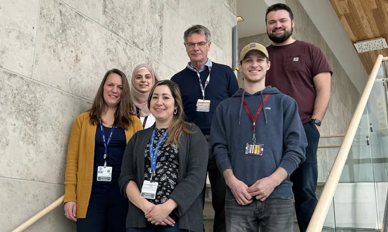 Members of the TOH Cancer Research Program Green Team standing together on an indoor staircase.