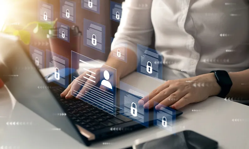 Person typing on a laptop with floating padlock and document icons, representing digital privacy and secure data access.